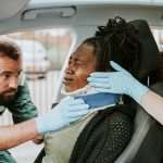 Paramedic placing a cervical collar to an injured woman from car
