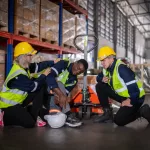 Men in work space helping an injured fellow for WCB