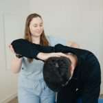 Chiropractor checking elbow of a patient