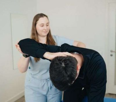 Chiropractor checking elbow of a patient