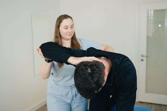 Chiropractor checking elbow of a patient