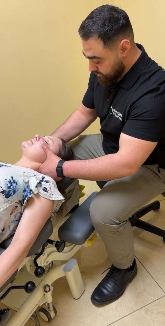 Physiotherapist performing neck and jaw manual therapy on a patient at Scona Sports Physiotherapy